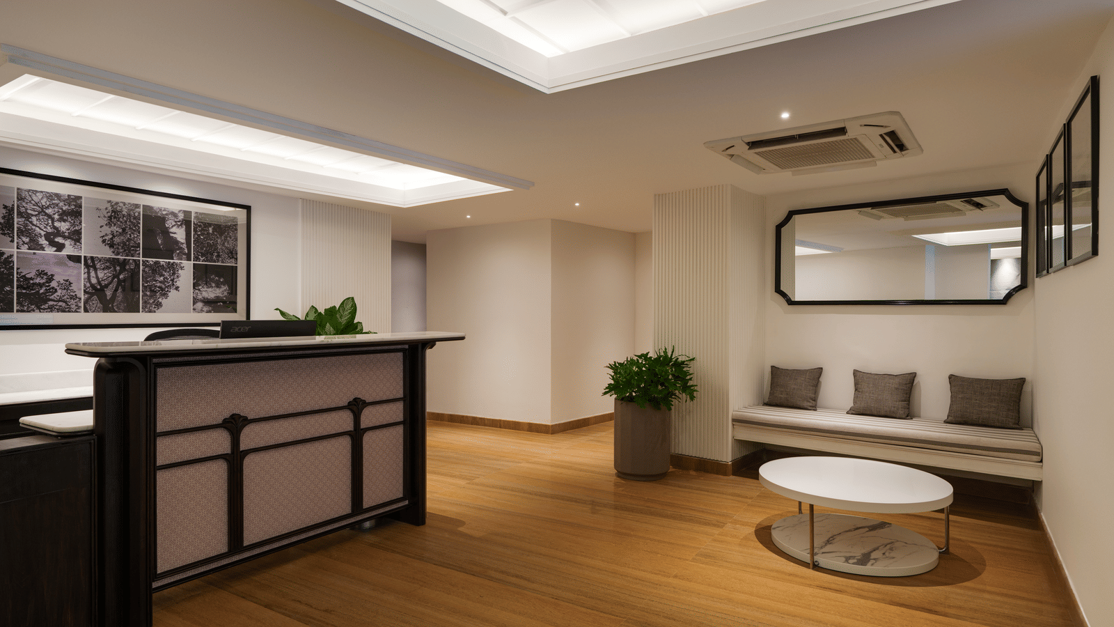 Elegant lounge area at Shilton Suites, Bengaluru, with a reception counter, seating, and wall mounted artwork.
