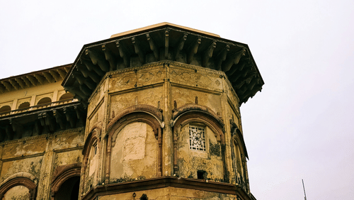 A view from below of an old building in Tijara with clear sky in the background.