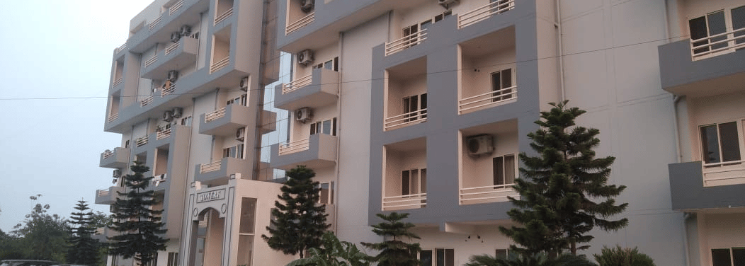 Front facade of a  Livbox, Rudrapur with parked bikes and greenery.