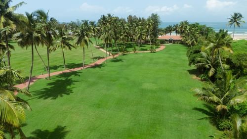 image of a lush green lawn at kenilworth resorts and spa, goa with a clear blue sky in the background