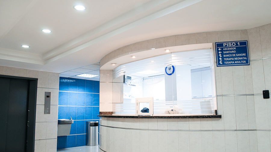 Reception desk featuring a counter and wall signage in a lobby.