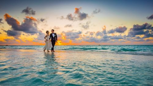 bride and groom walking on the beach