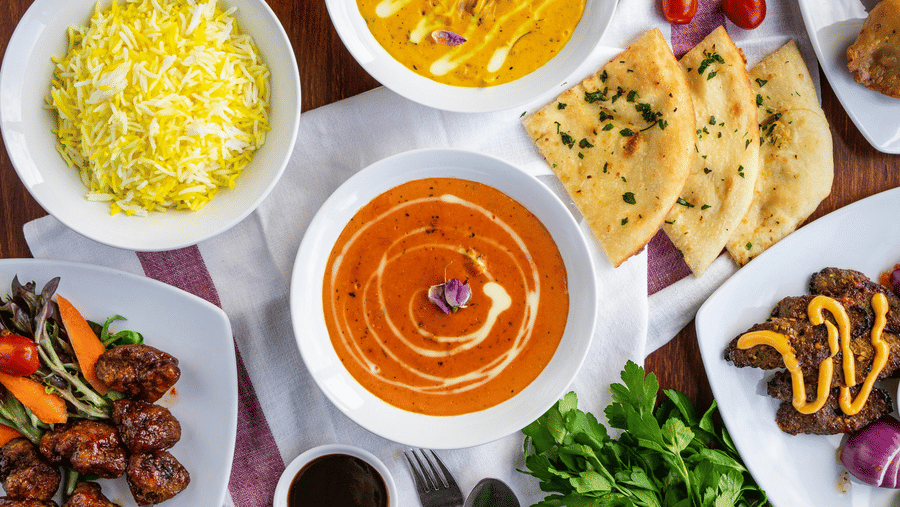 A top shot of a delicious spread of various Indian dishes served on a table.