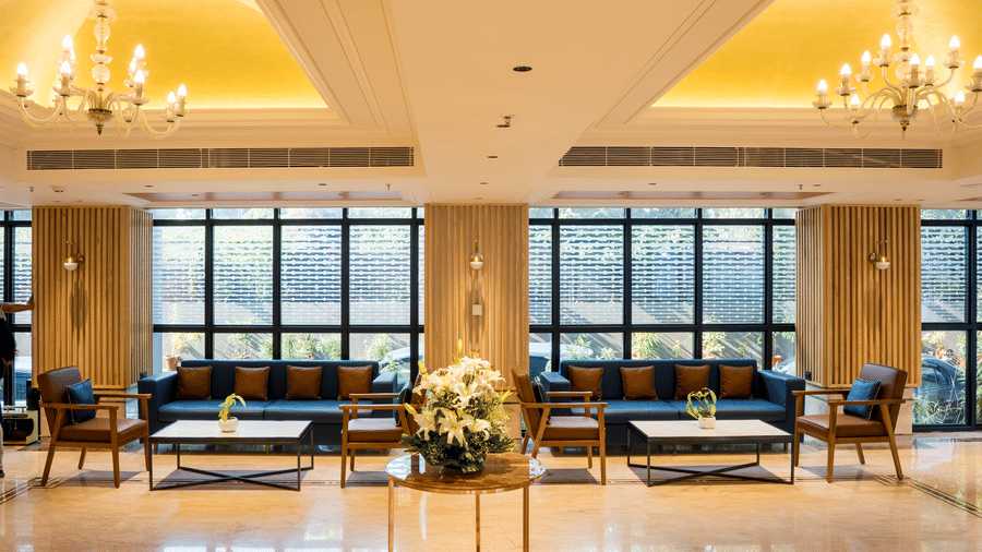 Lobby area with sofas, chairs, tables, decorative lights, and big windows at Gemini Continental.