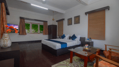 The Club King Room of Central Gleneagles Heritage Resort showcasing a double bed, wooden flooring,  seating area, and windows.
