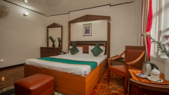 An image of a Club Room featuring a double size bed, dressing table, chair and a table with tea and coffee maker at Central Hill Resort, Gangtok