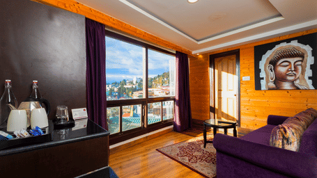 Well-lit Sumitel Hotels bedroom with modern furnishings, elegant color palette, large bed, wooden interiors, and thoughtfully arranged decor for a peaceful stay experience.  5.