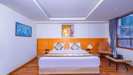 Elegant bedroom at Sumitel Premier Inn, Siliguri, designed with wooden flooring, soft lighting, and a cosy bed offering a peaceful and welcoming ambience.