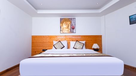 Spacious guest room at Sumitel Premier Inn, Siliguri, with a large comfortable bed, modern décor, and soft lighting creating a relaxing atmosphere.