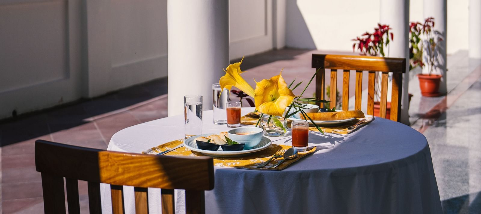 A table for two, neatly set for dining on the balcony at BluSalzz Villas - The Green Roof, Bhimtal.
