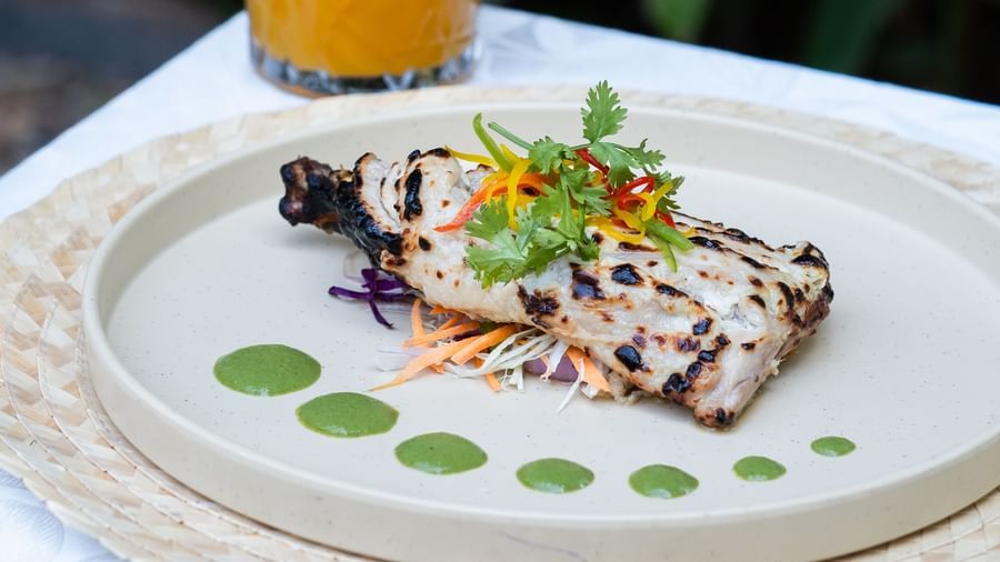 A plate of tandoori chicken with a drink next to it | Mango Hill, Pondicherry