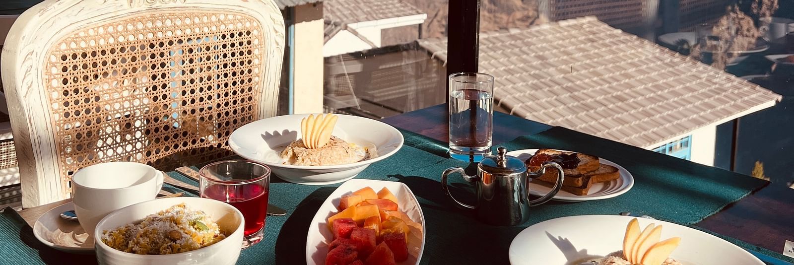 Image of a variety of food on a table and veiws of the mountian | Faraway Cottages, Auli