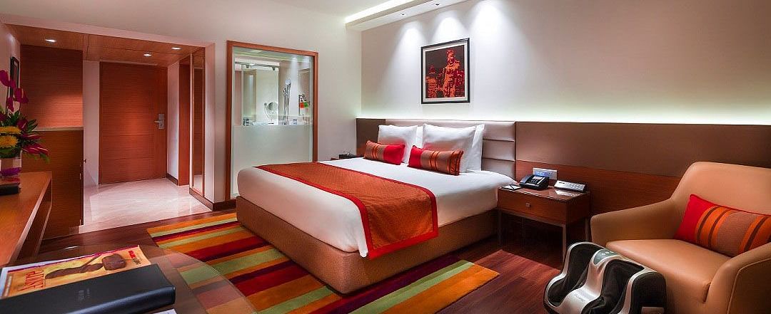 Grand Club Room with king size bed and sofa chair at Grand Chennai By GRT Hotels.