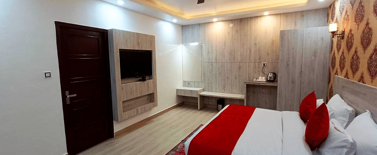 A Premium Room at DLS Nature Trinket Resort with a king size bed, a television, and a side table.