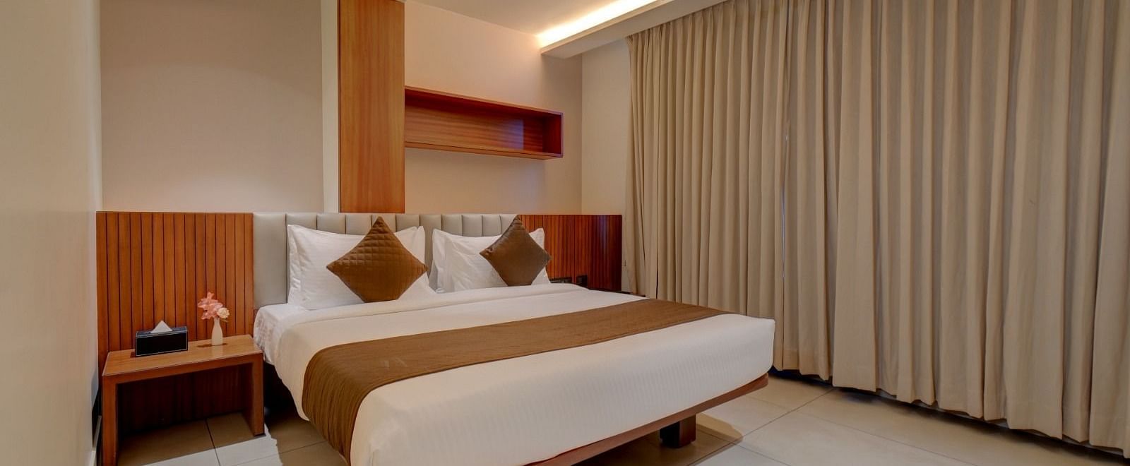 Image of a room with a bed and a table beside it at Hari Govindas, Siddappa Square.