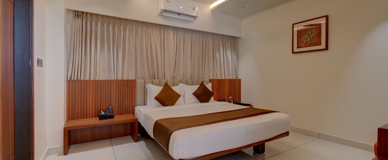 An image of a room at Hari Govindas, Siddappa Square, featuring a bed with an air conditioner mounted above it.
