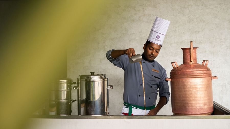 Chef pouring tea in a traditional setting at The Residency Towers