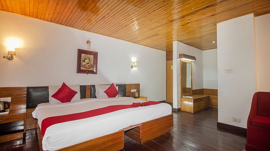 Spacious bedroom with a double bed, side tables, and a window with curtains.