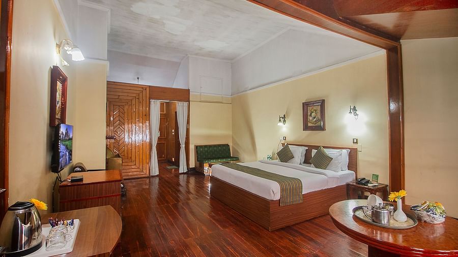 Heritage Club King Room at Central Heritage Resort & Spa, The Mall, Darjeeling - a spacious and elegant accommodation with classic decor and wooden flooring.