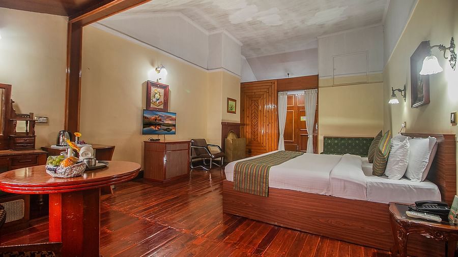 Heritage Club King Room at Central Heritage Resort & Spa, The Mall, Darjeeling - a spacious and elegant accommodation with classic decor and wooden flooring.