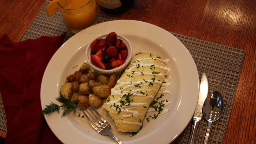 An omelette served with potatoes and strawberries - Brewery Gulch Inn & Spa