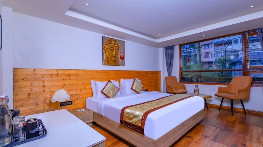 Elegant guest room at Sumitel Premier Inn, Siliguri, with wooden wall panelling, a double bed, and soft lighting creating a warm and relaxing atmosphere.