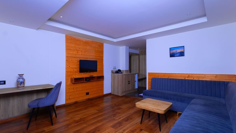 Modern guest room at Sumitel Premier Inn, Siliguri, featuring wooden flooring, contemporary furniture, and a flat-screen TV for guest convenience.