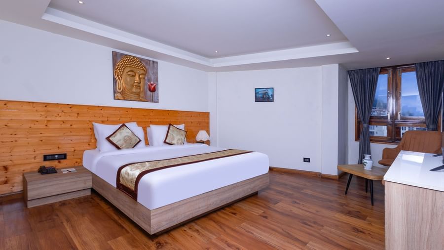Elegant bedroom at Sumitel Premier Inn, Siliguri, with wooden accents, a cosy double bed, and stylish interiors that create a warm and inviting stay.