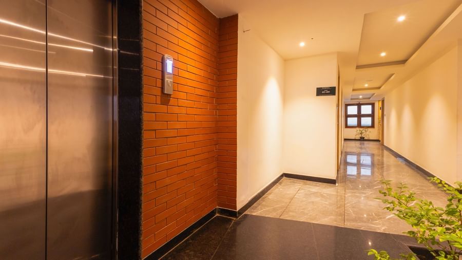 Lift lobby at Sumitel Premier Inn, Siliguri, with polished flooring, wooden panels, and contemporary lighting that reflects the hotel’s modern design.