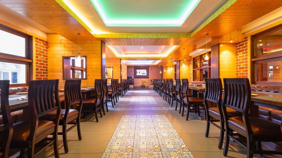 Restaurant seating area at Sumitel Premier Inn, Siliguri, with elegant décor, soft ceiling lights, and neatly placed tables offering a stylish dining experience.