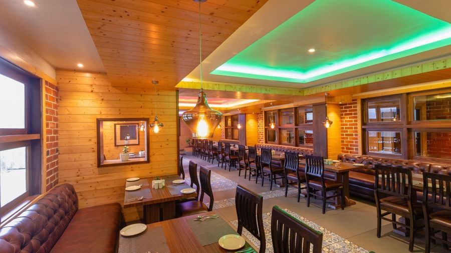 Bright restaurant space at Sumitel Premier Inn, Siliguri, with comfortable seating, warm lighting, and wooden accents designed for a pleasant dining environment.