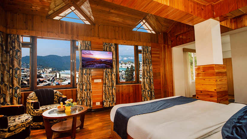 A cosy room at Central Heritage Resort & Spa, one of the hotels in Darjeeling with Kanchenjunga view, features warm wooden interiors and elegant furnishings.