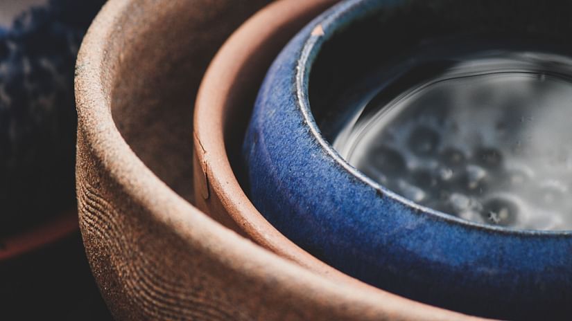 three Pots kept inside each other with two pots being brown and the last one being blue