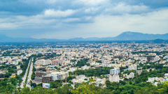 aerial view of a tirupati with many building and a mountain in the background