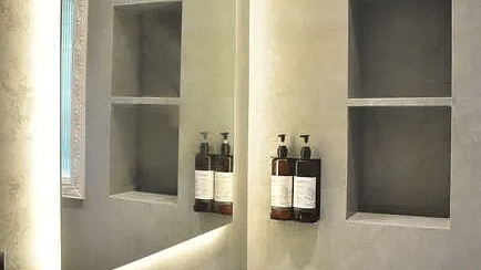 A bathroom at Karma Chalets showing a white sink, wall-mounted mirror cabinets, and toiletries on shelves.