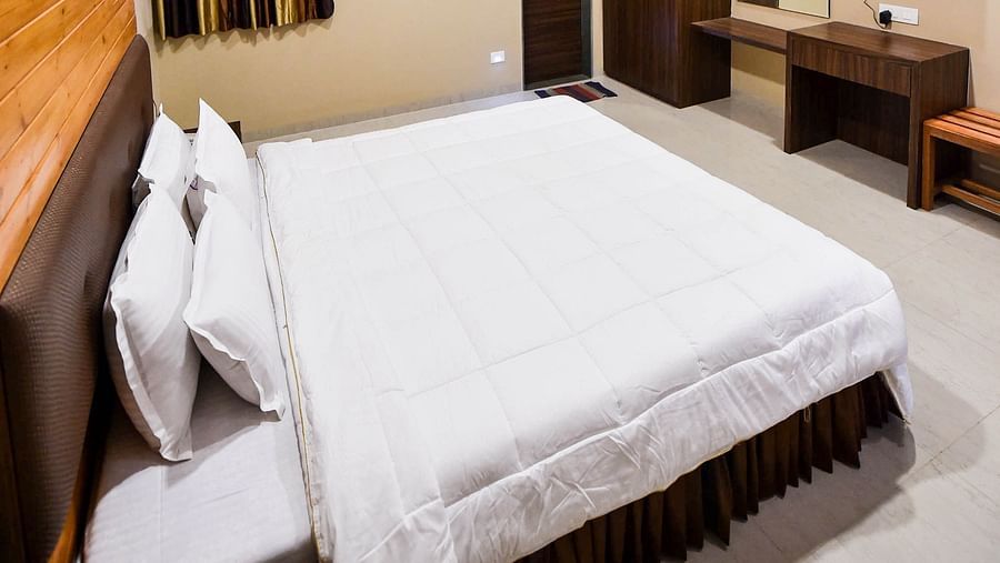 Interior of Deluxe Cottage at the Kanila Resort with a bed, bedside tables, and a ceiling fan.