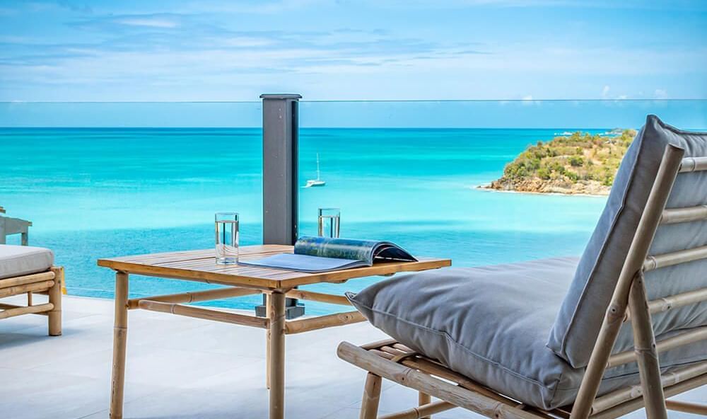 Relaxing beachside loungers at Tamarind Hills Resort and Villas Antigua, overlooking calm Caribbean waves.