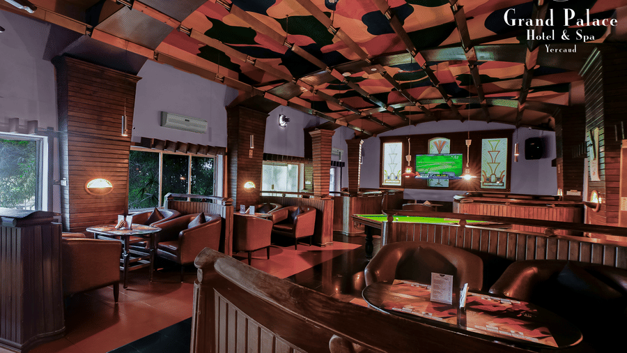 Cloud-9 Bar at Grand Palace, Yercaud showing seating booths, bar counter, billiards table, and wooden ceiling panels.