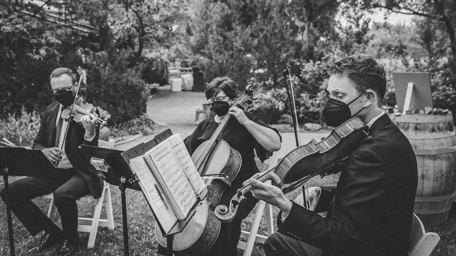 An overview of a band playing music outdoors during a wedding.