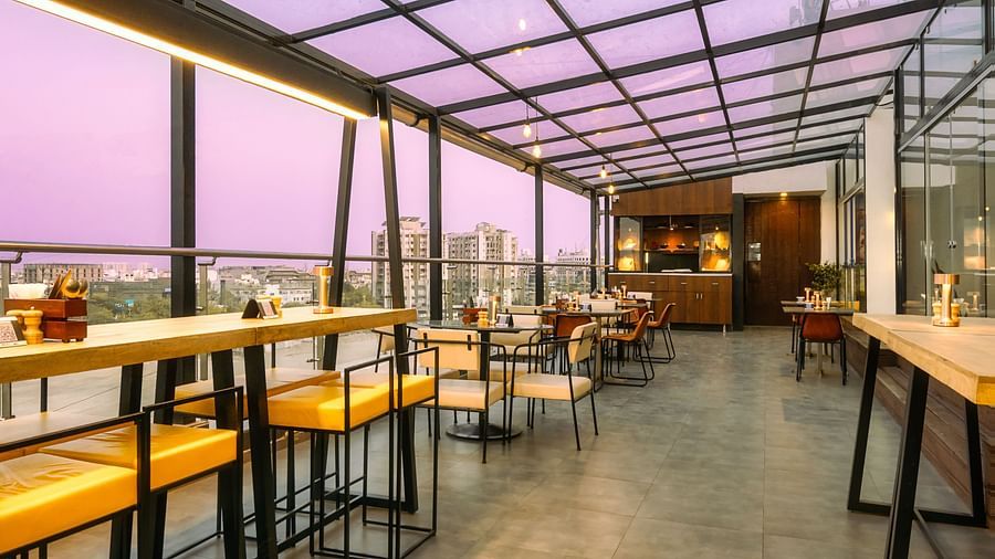 A long shot of the rooftop cafe with comfy seating and beautiful view at at Marasa Sarovar Portico, Rajkot