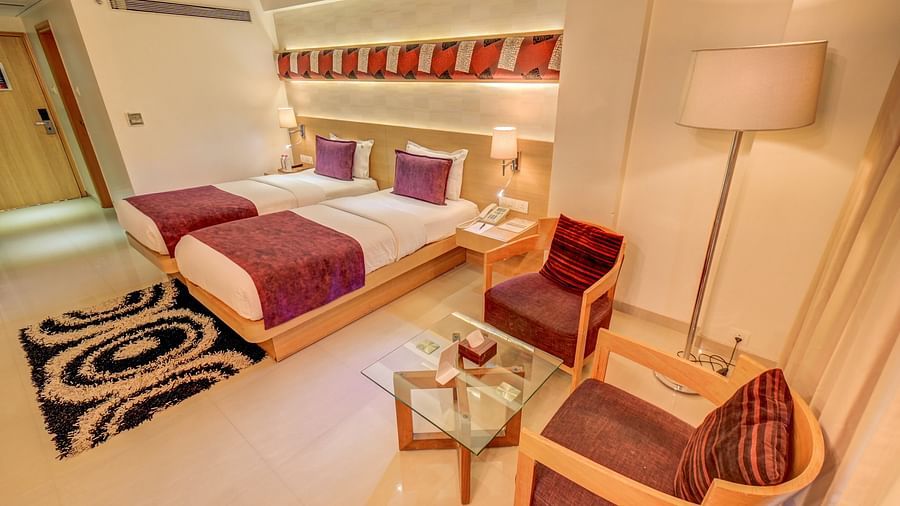 a view of the twin bed and seating area at Premium room at The SSK Solitaire Hotel & Banquets, Mumbai Naka - Nashik