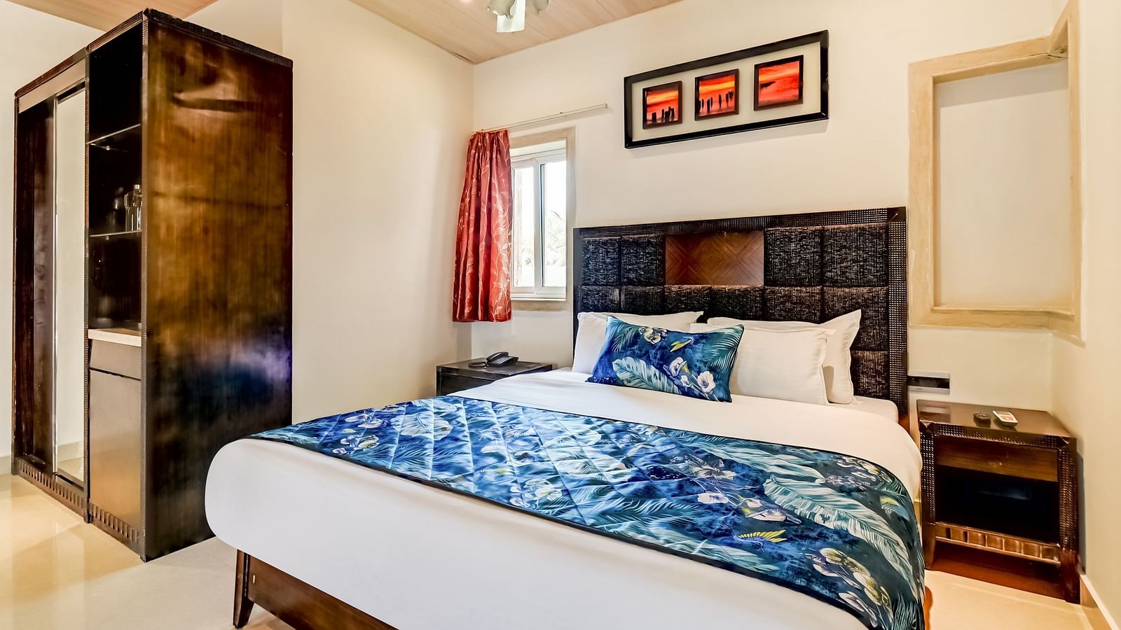  Generously sized bed accompanied by two wooden bedside tables and a large wooden wardrobe