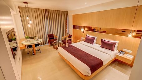 a view of the king sized bed and seating area at Deluxe room at The SSK Solitaire Hotel & Banquets, Mumbai Naka - Nashik