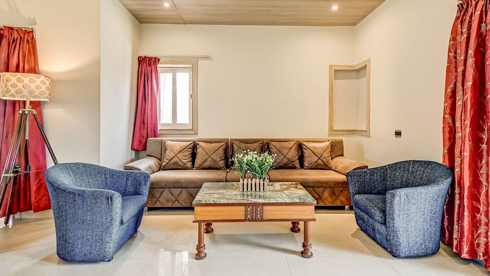 Two sofas positioned opposite each other with a table between them, complemented by a large side sofa adorned with pillows