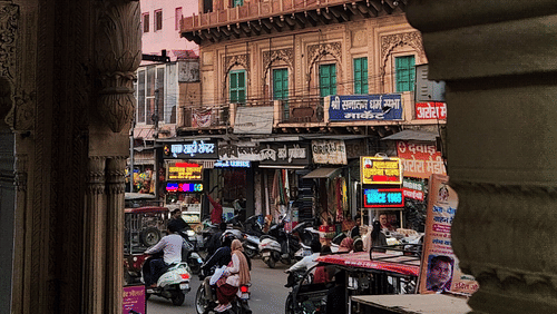 A view of a busy street in Jaipur surrounded by vibrant architecture framed by an ornate arch.