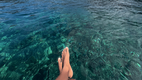 View of Barren Island volcano from a boat with clear turquoise water and open sky captured during a dive trip with Barefoot Scuba Resort.