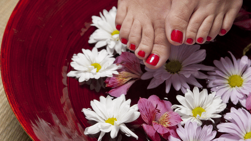 Feet hovering over a bowl of water with flowers