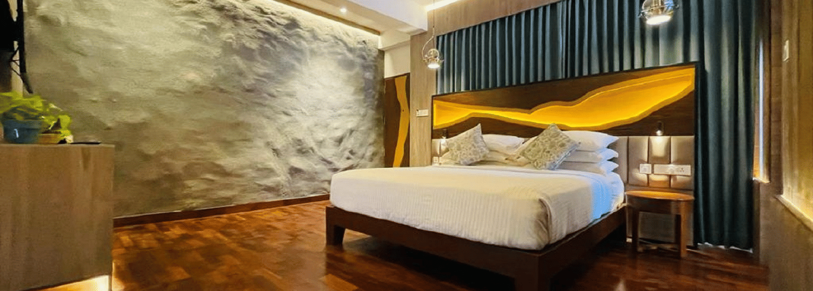 An image of timber Lodge room with a king size bed, ceiling fan, decorative items, and wall paintings - GReaT trails Kodaikanal by GRT Hotels