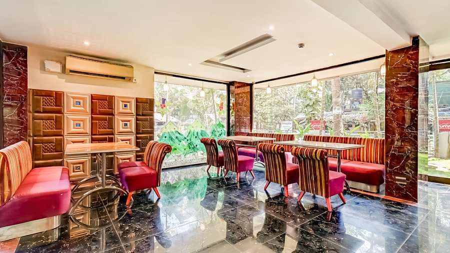  Dining area with cushioned sofas surrounding the table on all four sides, and ceiling fans installed above for added comfort