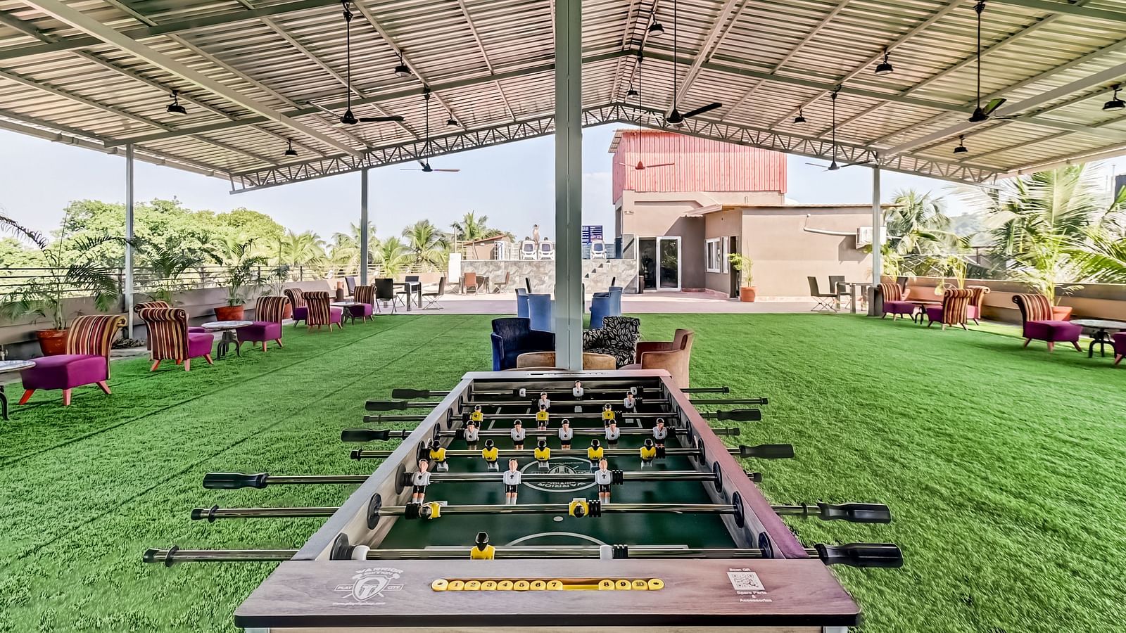  A foosball table positioned in the deck area, surrounded by multiple sofas